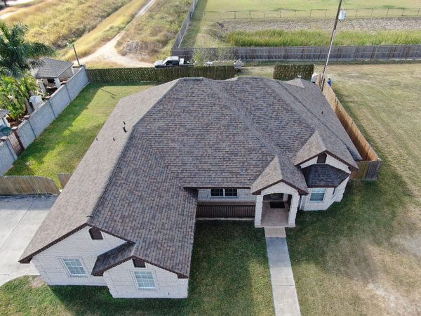 luxury home with gray shingles done by xyz Residential roof restoration Harlingen.
